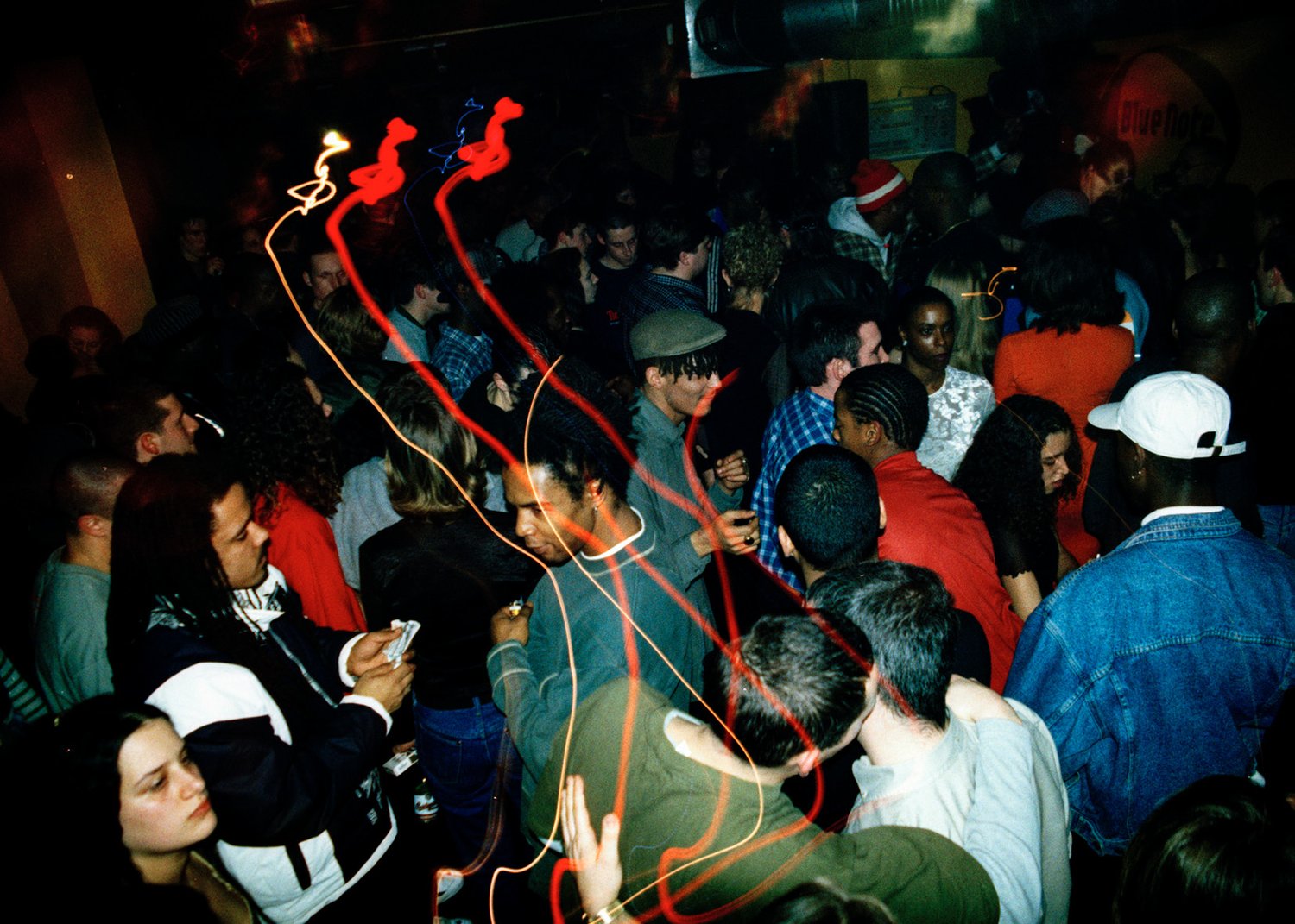 Crowd of people at a party with red and orange strobe lights