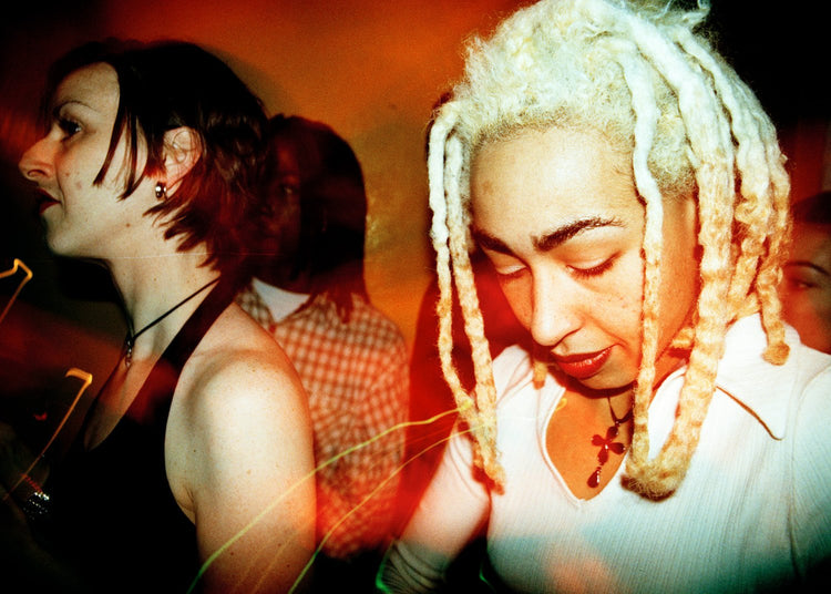 Two women at a nightclub with a warm, blurred background
