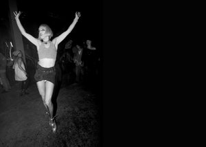 Person dancing with arms raised at a rave.