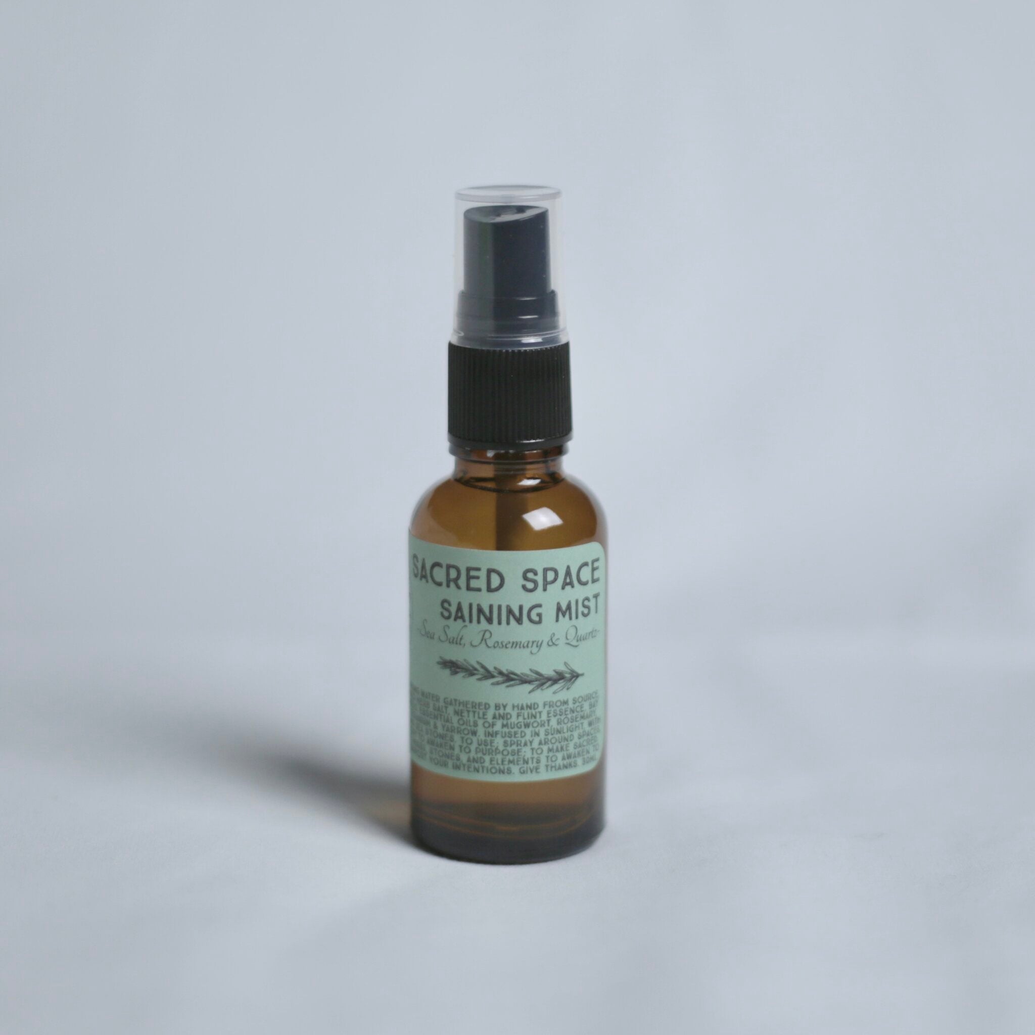 Bottle of 'Sacred Space Saining Mist' on a gray background