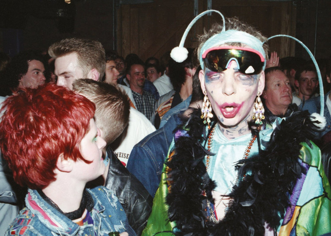 Person with elaborate makeup and costume in a club.
