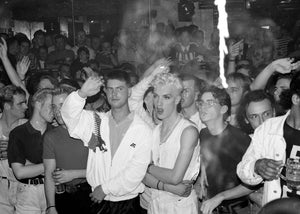 People dancing in a crowded club with a focus on a couple in the center.