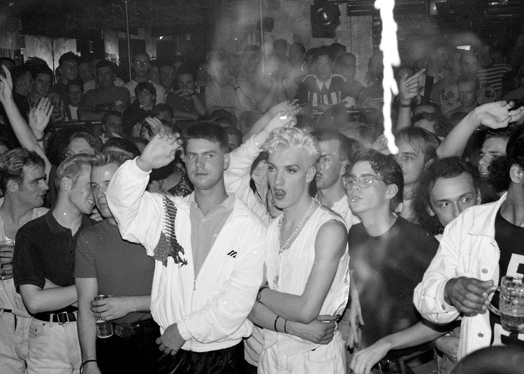 People dancing in a crowded club with a focus on a couple in the center.