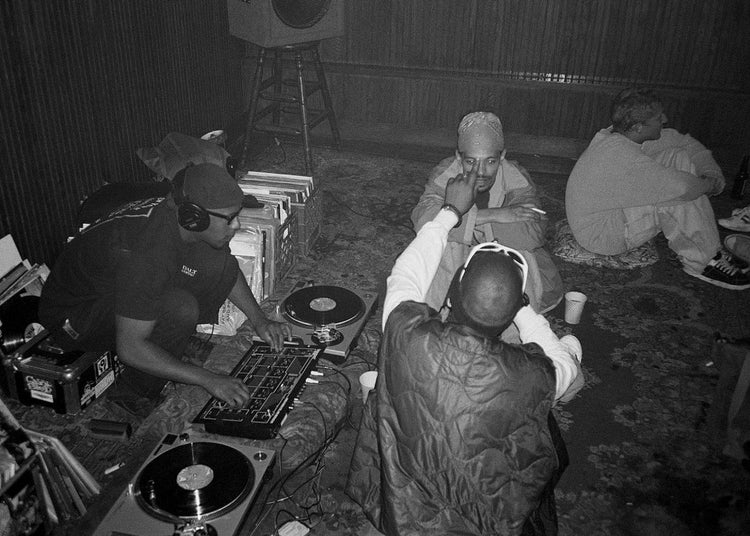 Group of people in a room with audio equipment sat on the floor.