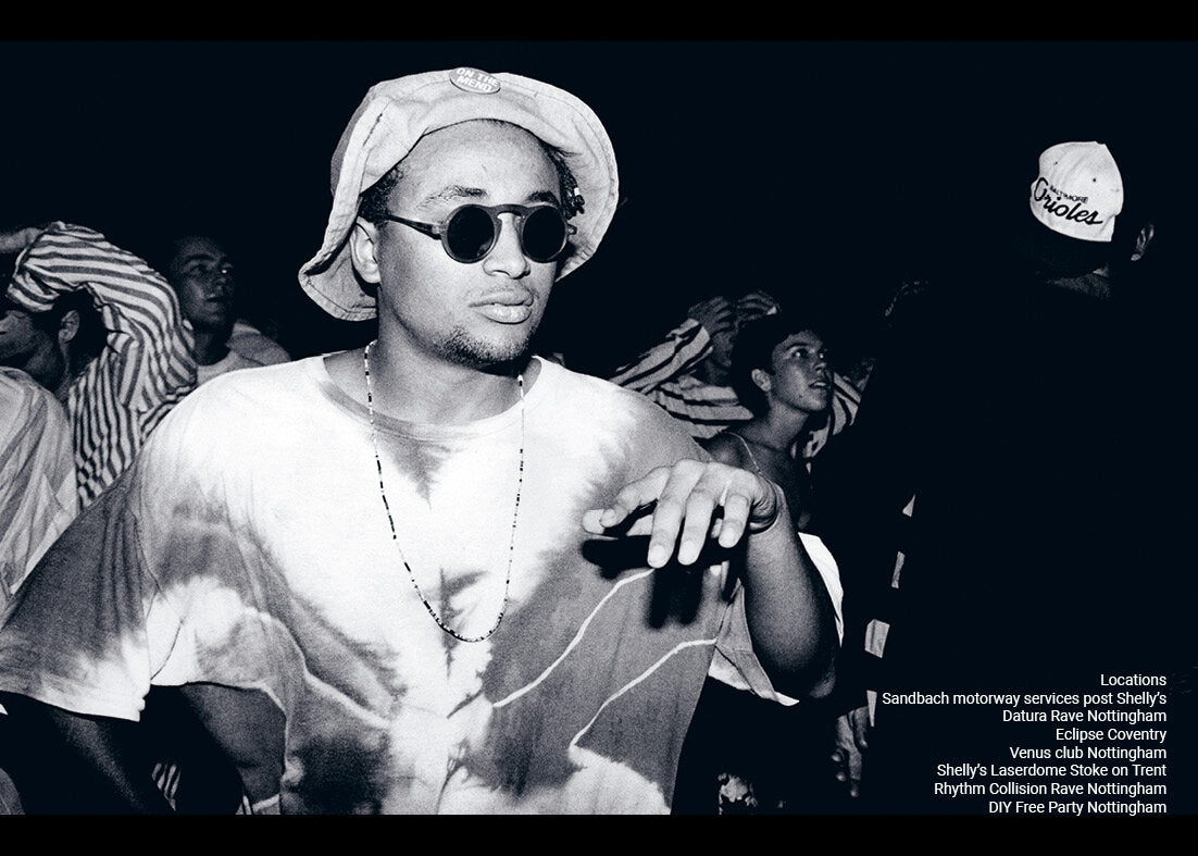 Black and white photo of a person wearing sunglasses and a hat on a dark background