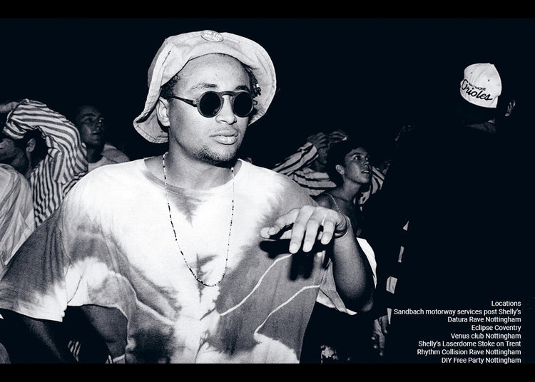 Black and white photo of a person wearing sunglasses and a hat on a dark background