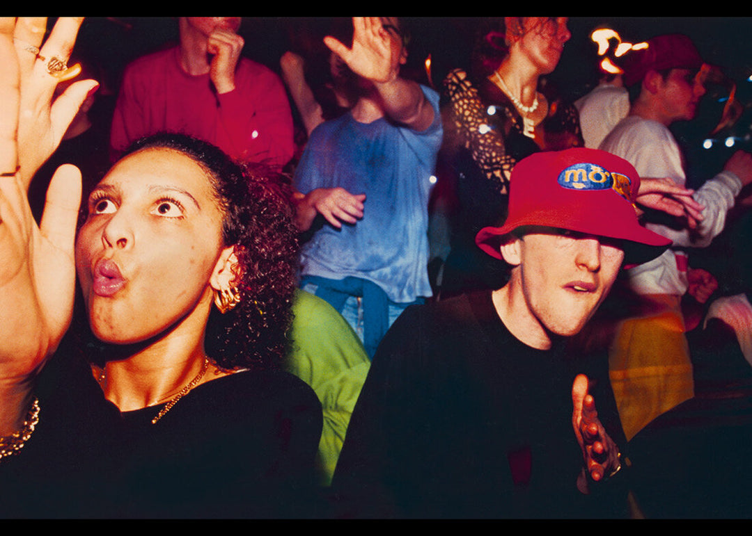 People in a crowd with one person wearing a red cap with 'MO' on it.
