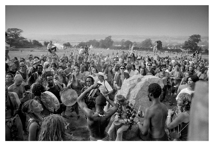 Black and white photo of a large crowd at a festival gathered around a central figure on a hilltop.
